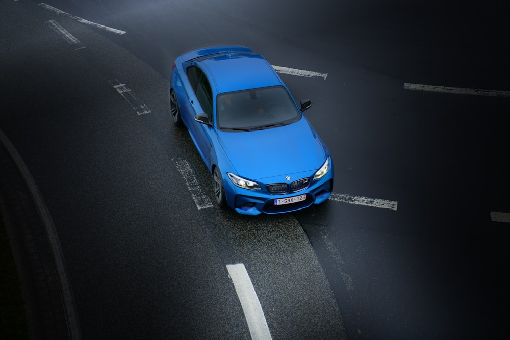 Photographie aérienne d’une berline bleue sur l’autoroute