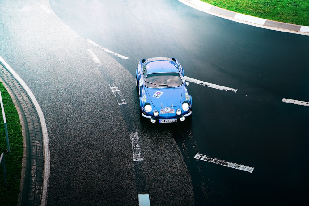 blue coupe on black road