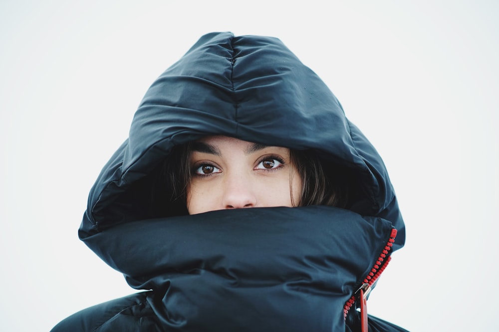 uma mulher em uma jaqueta preta com um capuz em
