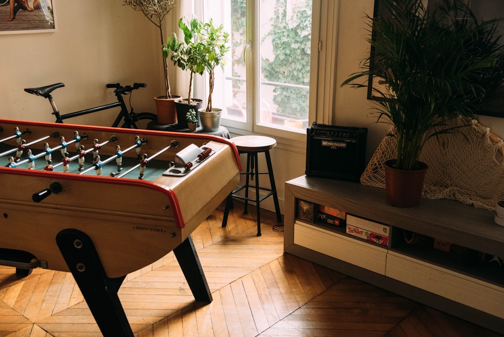 brown air hockey beside bicycle inside beige room