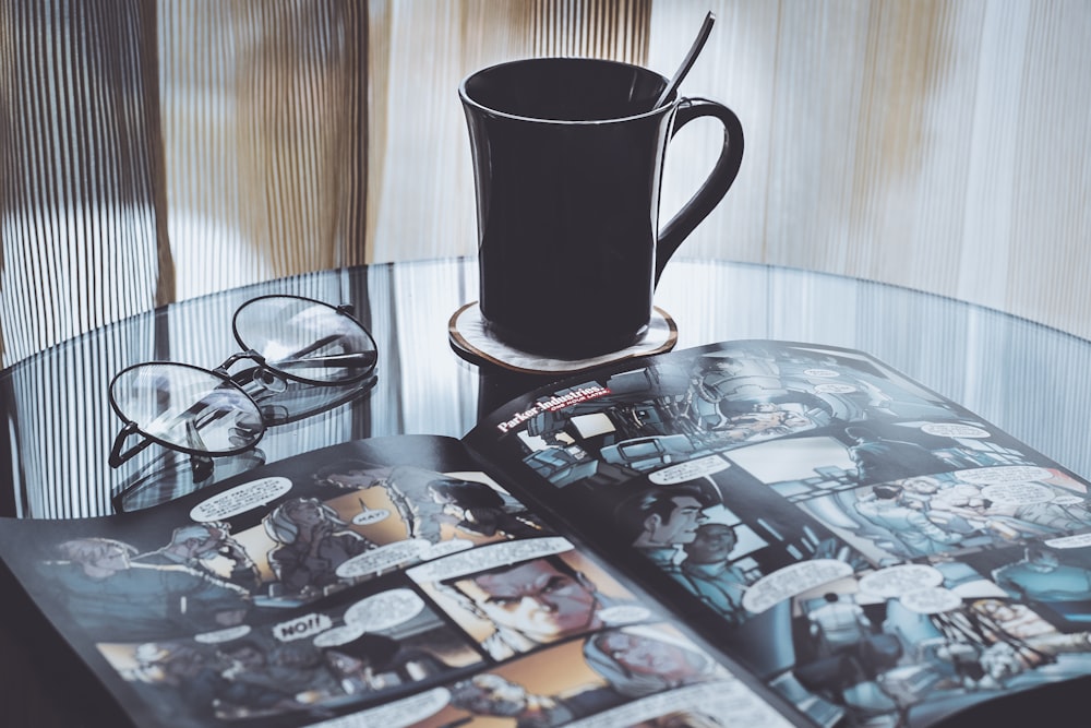 eyeglasses near mug on table