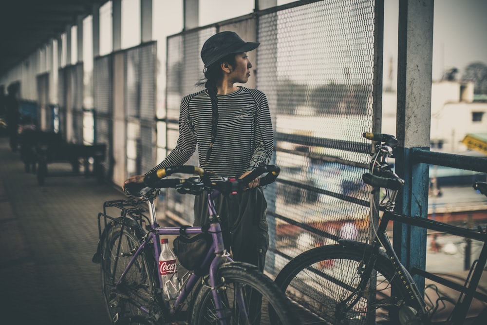 보라색 도시 자전거를 들고 있는 여자