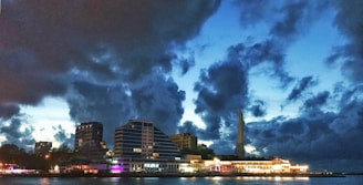 Dark overlay image of Neuquén cityscape at dusk, highlighting modern buildings and streets.