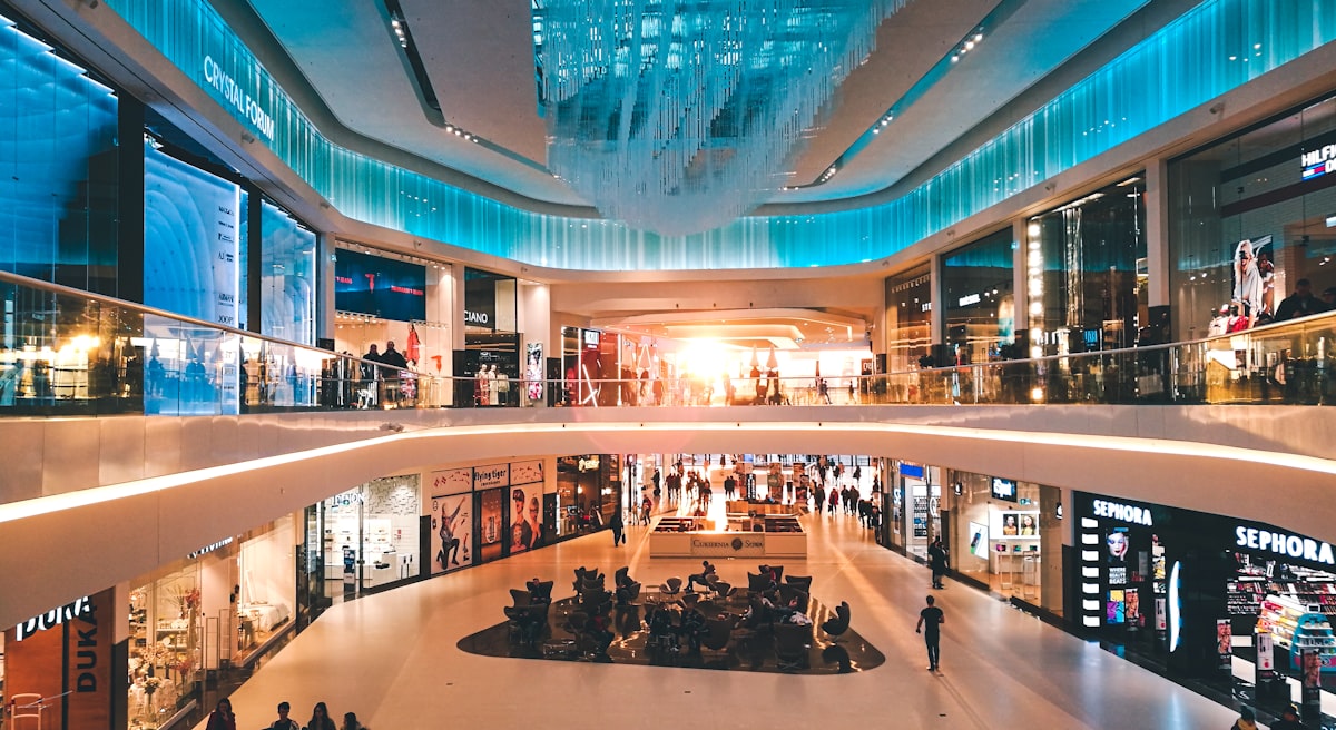 Modern shopping mall interior with shoppers and retail stores