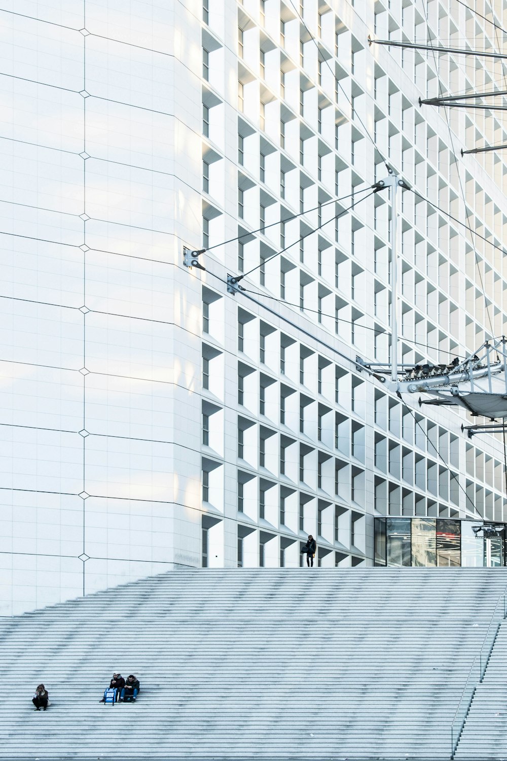 man standing beside white building