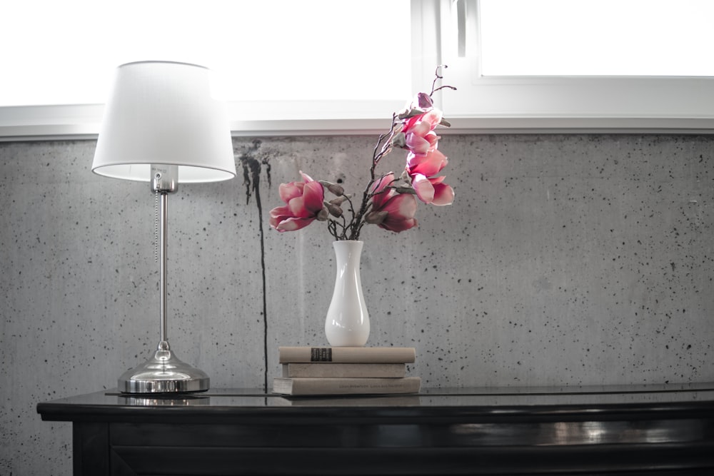 silver table lamp with white lampshade on top of black table