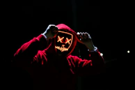 red hooded sweatshirt with computer screen face signifying malware