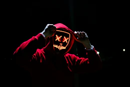 red hooded sweatshirt with computer screen face signifying malware