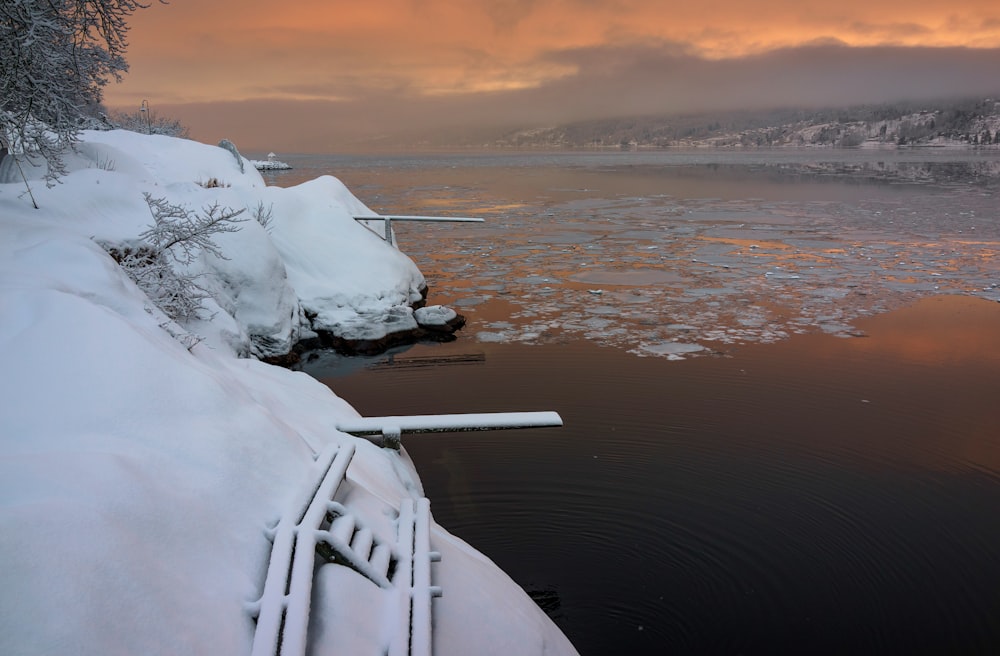 body of water beside snowy edge of land