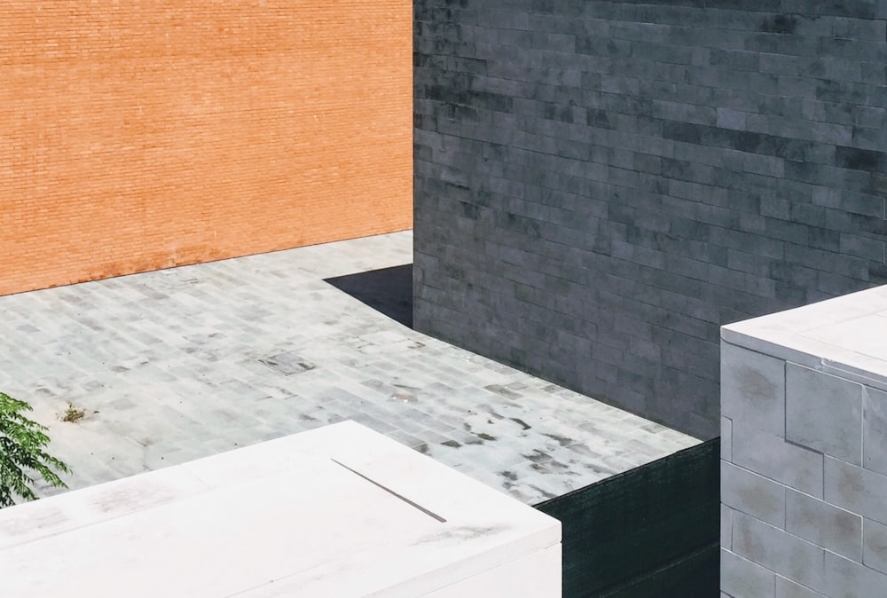 a black and orange building with a plant next to it