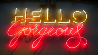 Bright neon sign displaying the words 'Hello Gorgeous' with 'Hello' in yellow and 'Gorgeous' in pink, providing a vibrant and welcoming visual.