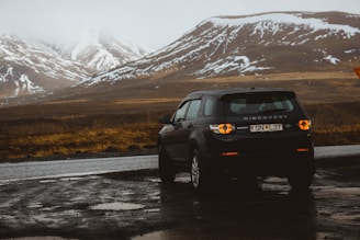 black Discovery SUV in front of asphalt road