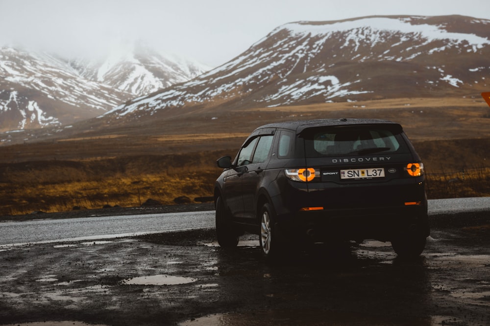 black Discovery SUV in front of asphalt road