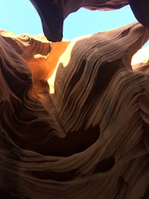 Close-up of the smooth, wave-like patterns in the canyon walls glowing in warm orange hues.