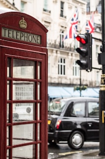 telephone booth beside a black car