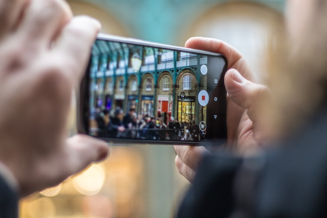 person holding smartphone taking video of people, Lives’ crossing