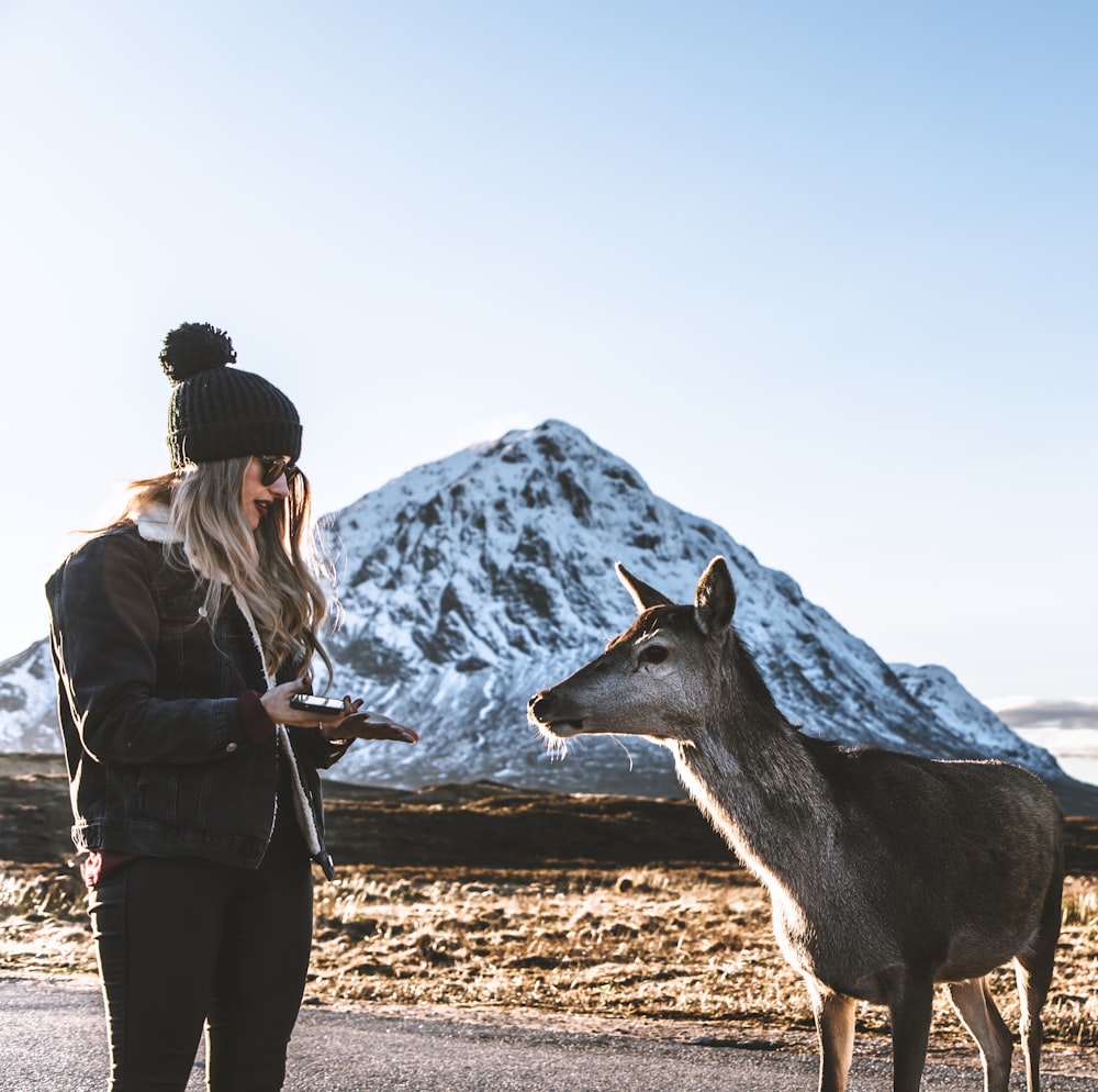 woman standing beside doe