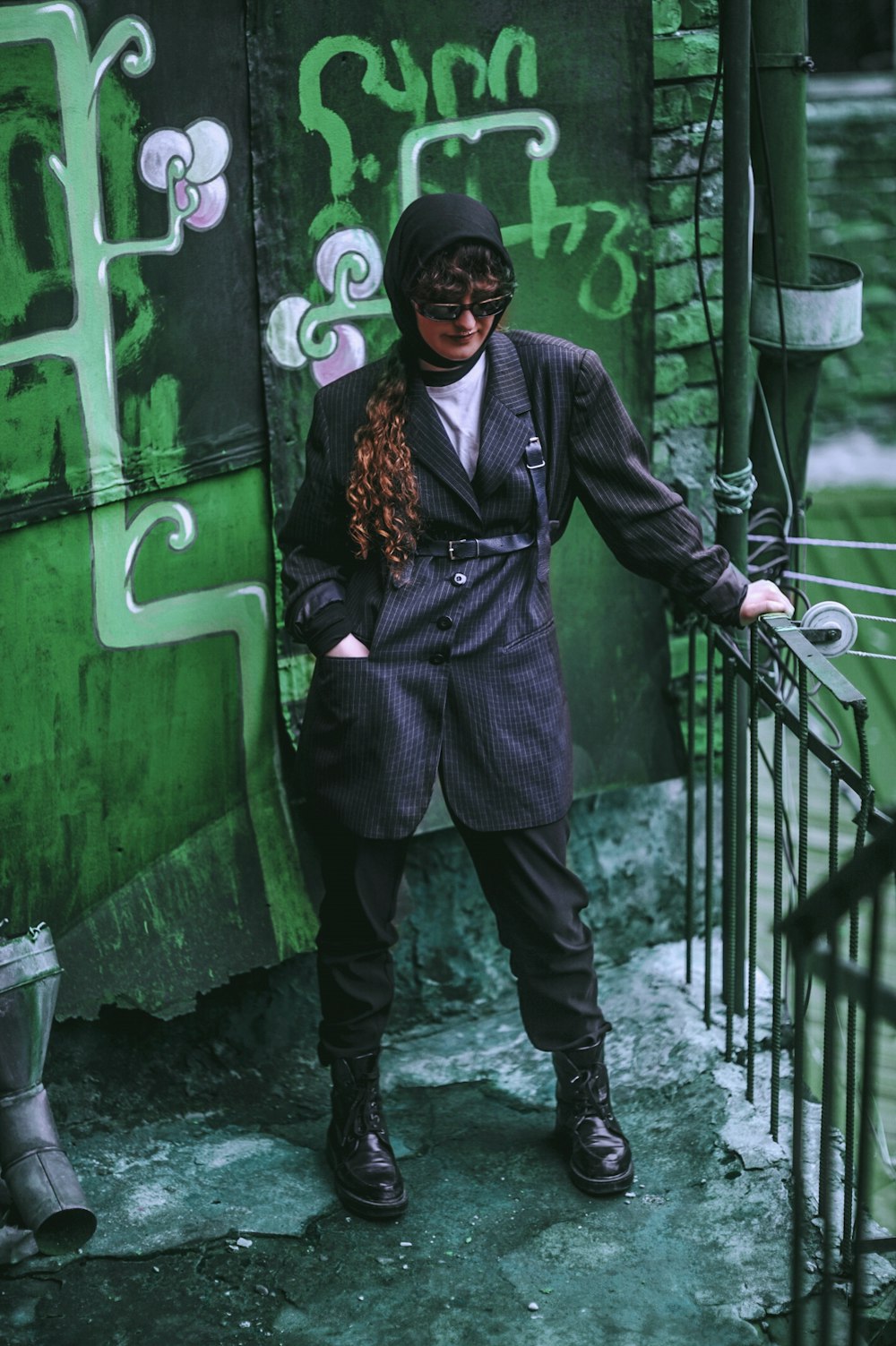 woman standing on corner holding metal rail