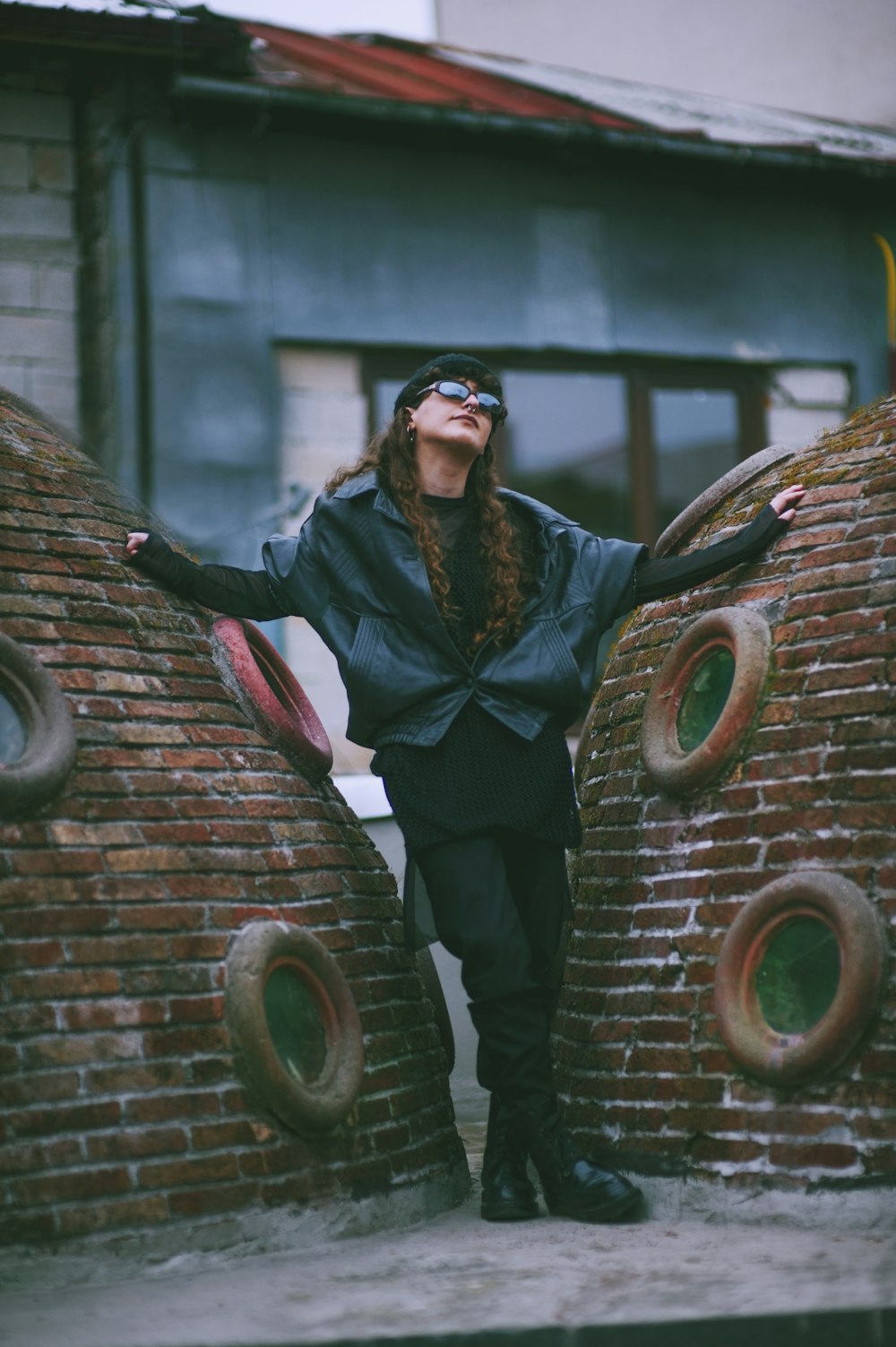 woman standing between red brick walls