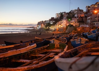 boats on seashore near houses