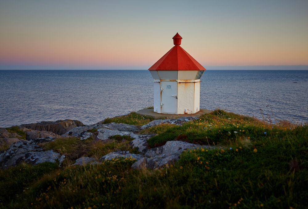 landscaped photo of a white and red house viewing body of water