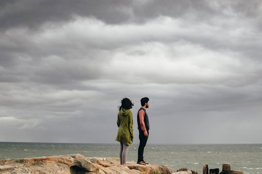 man and woman standing on cliff near sea in Cabo Polonio Uruguay