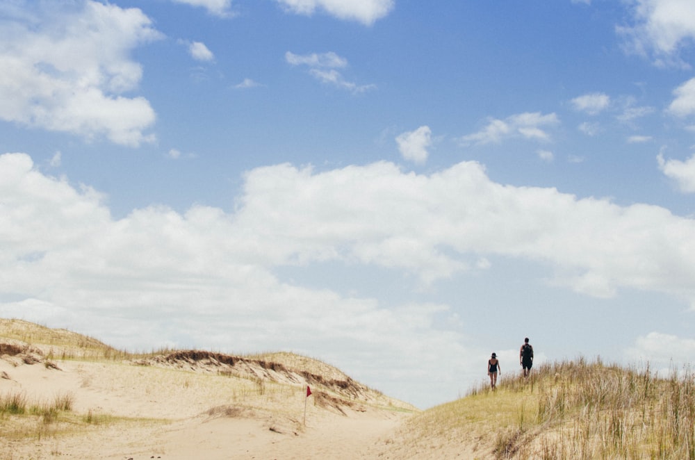 two person standing on dried field during daytime