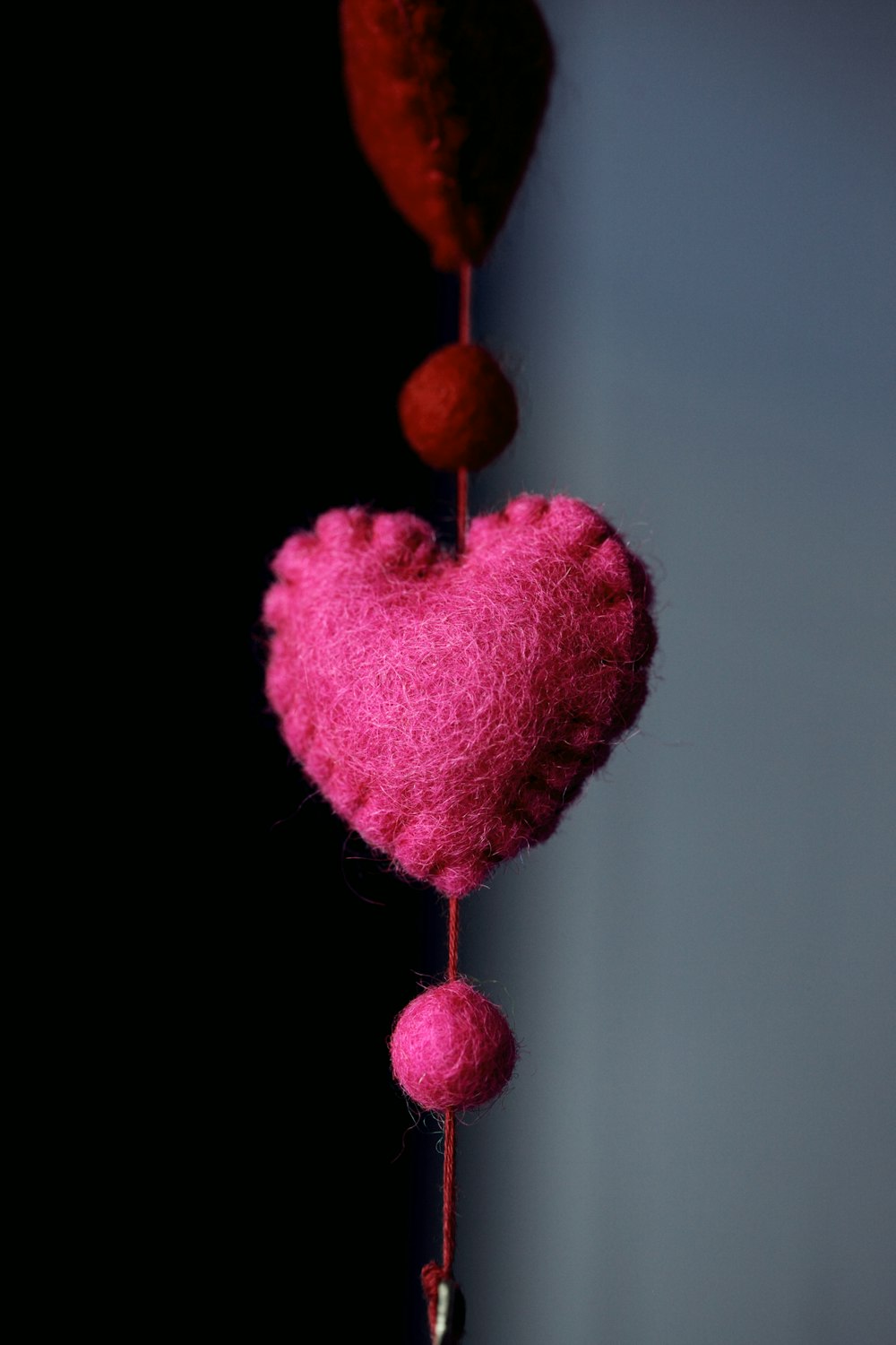a pink heart hanging from a hook on a wall