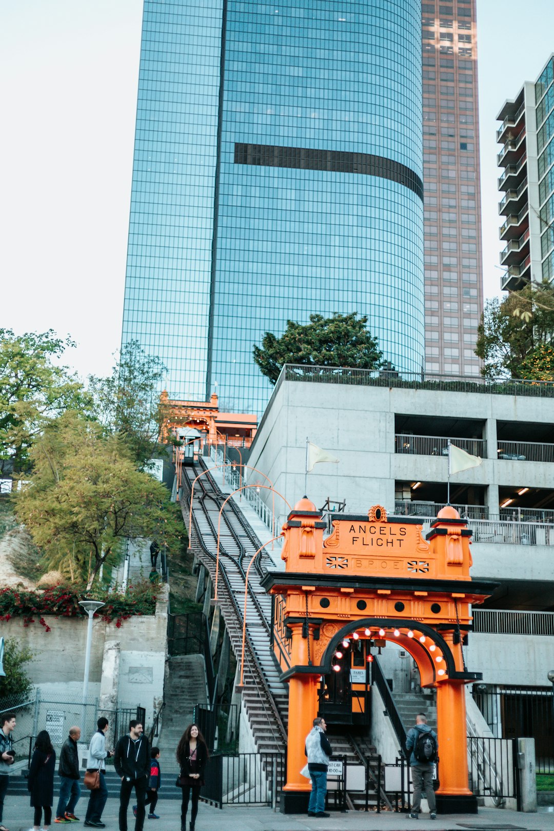 group of people standing outside of orange concrete archway