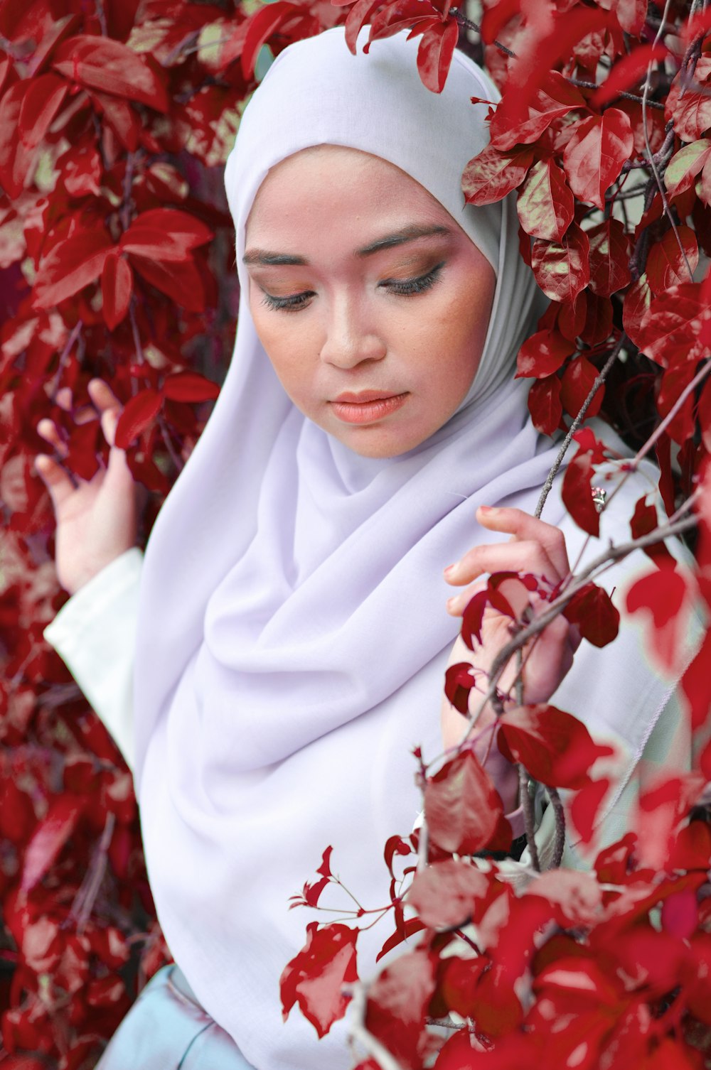 woman surrounded by red leaves