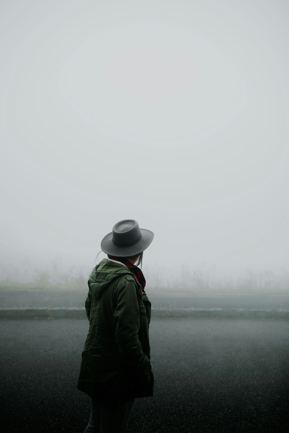 Persona de pie con vistas al bosque cubierto de niebla