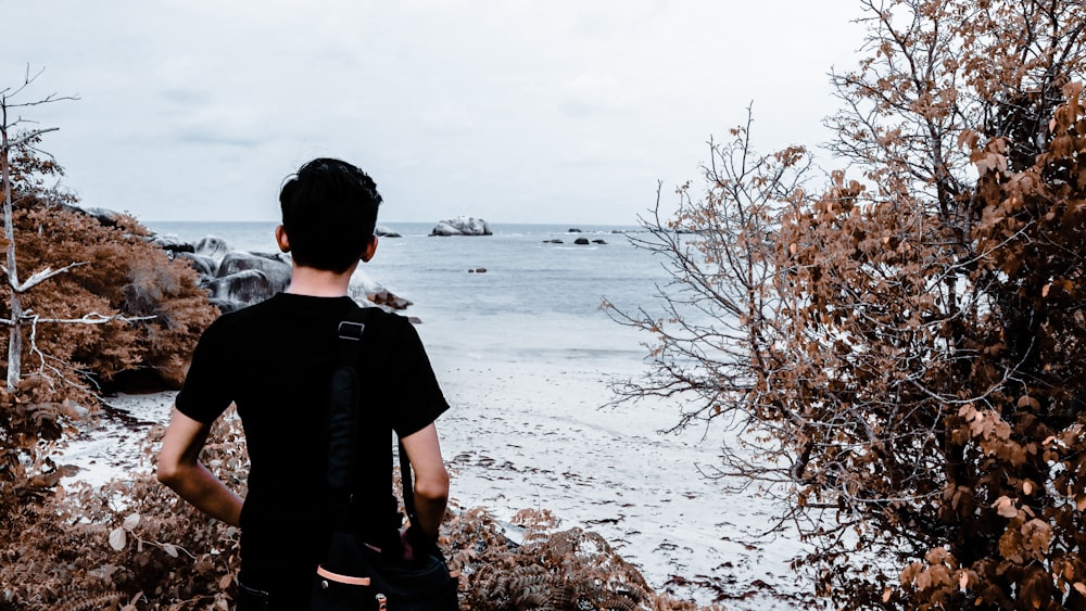 man standing near body of water