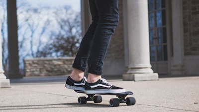 person riding on cruiser board leg zoom background