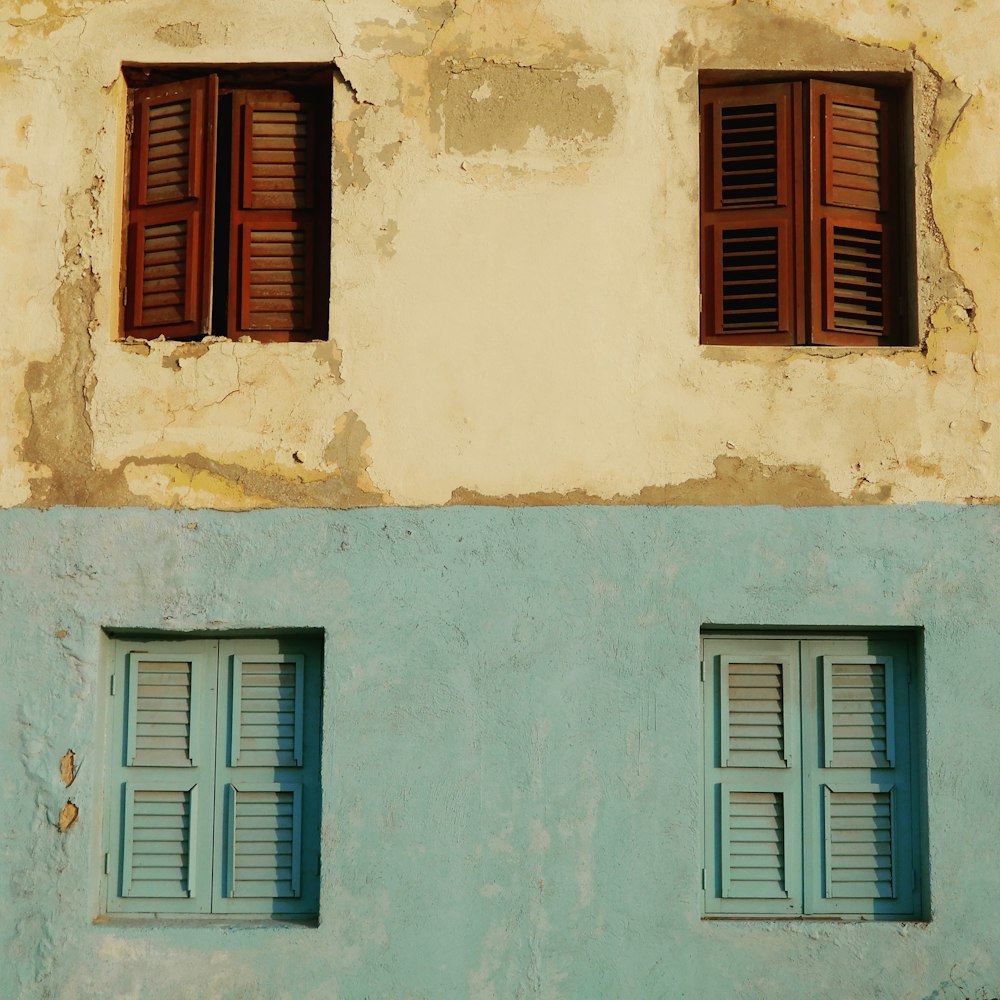 white and teal concrete structure with four windows