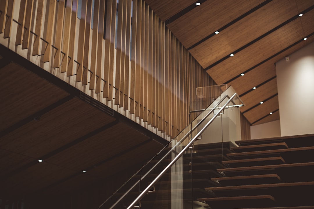 brown wooden stair with glass fence