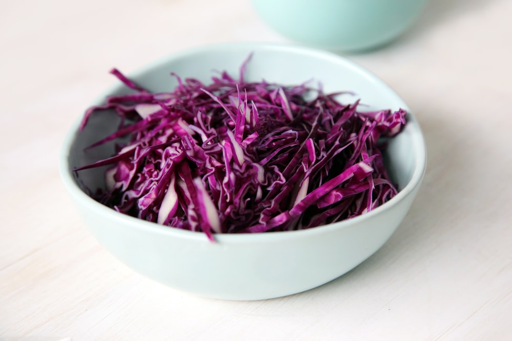 selective focus photography of purple petal filled bowl