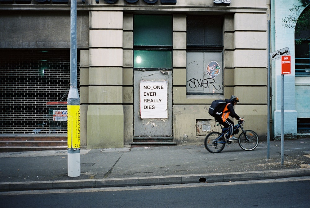 man riding bike in front of building during daytime