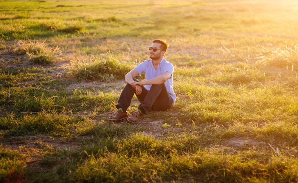 man sitting on green grass field