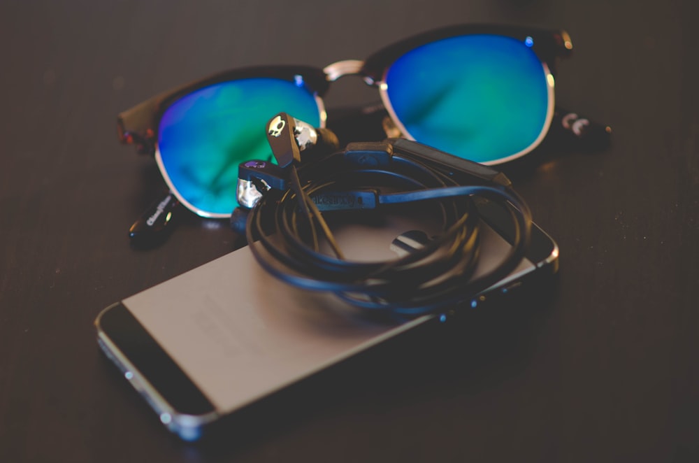 space gray iPhone beside Clubmaster-style sunglasses