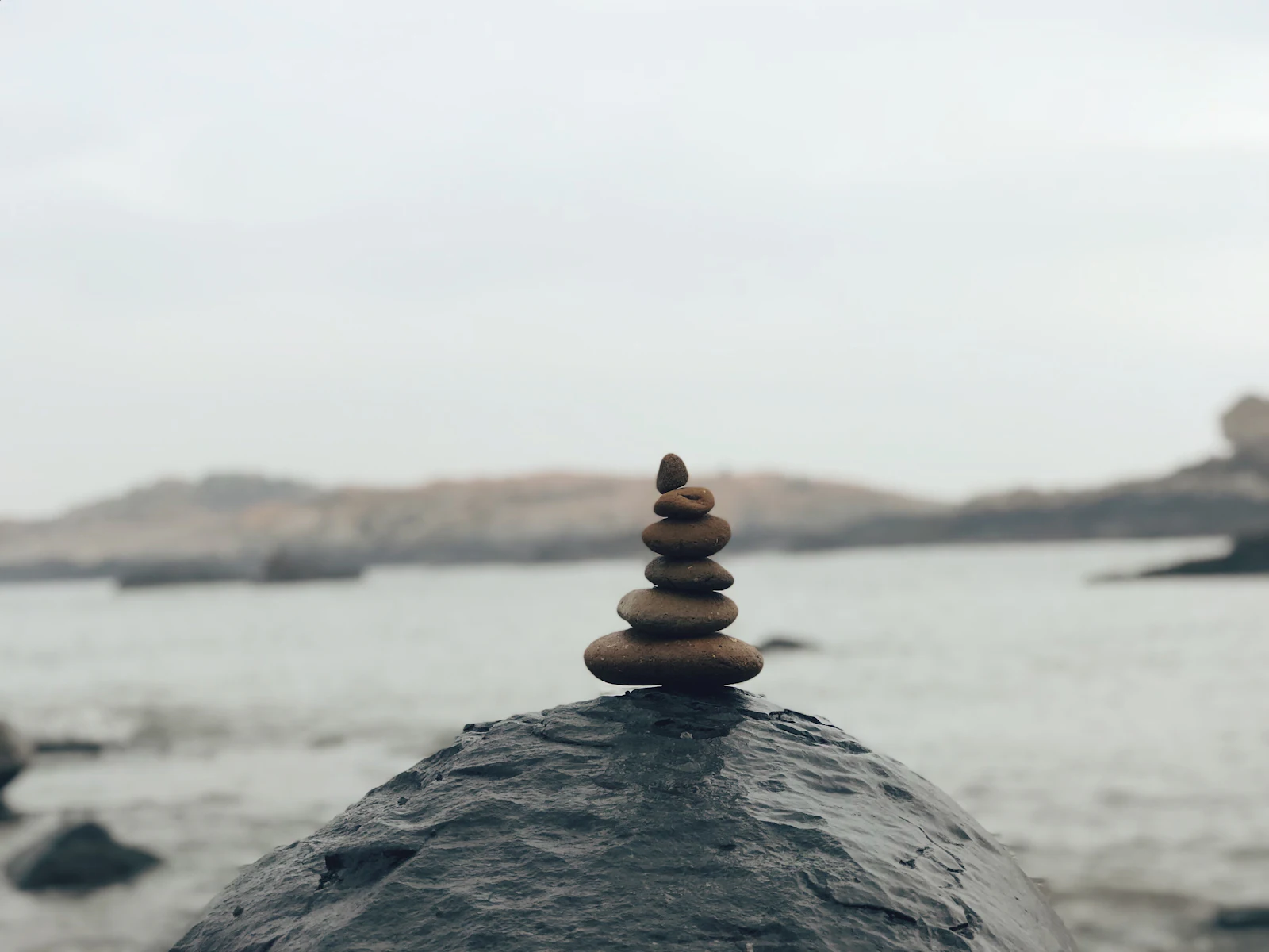 A cairn of stones on a rock above the sea