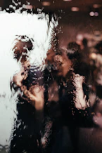 blurry reflection of light of two persons on glass window