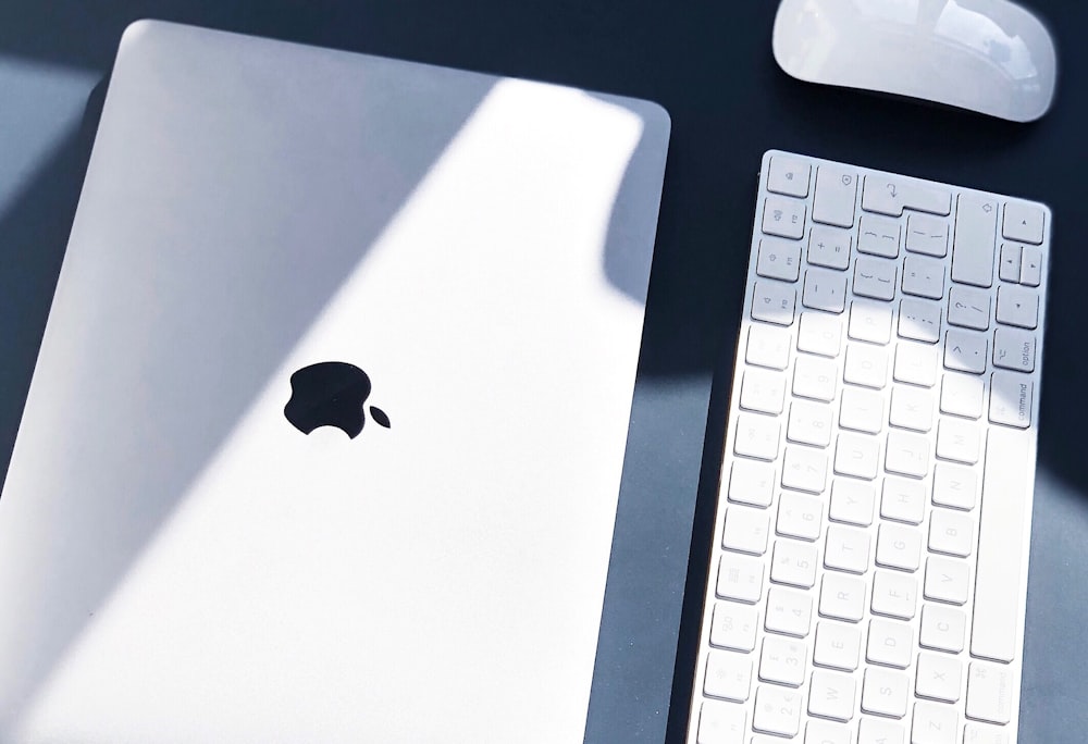 Fotografía plana de MacBook blanco, Apple Wireless Keyboard y Magic Mouse