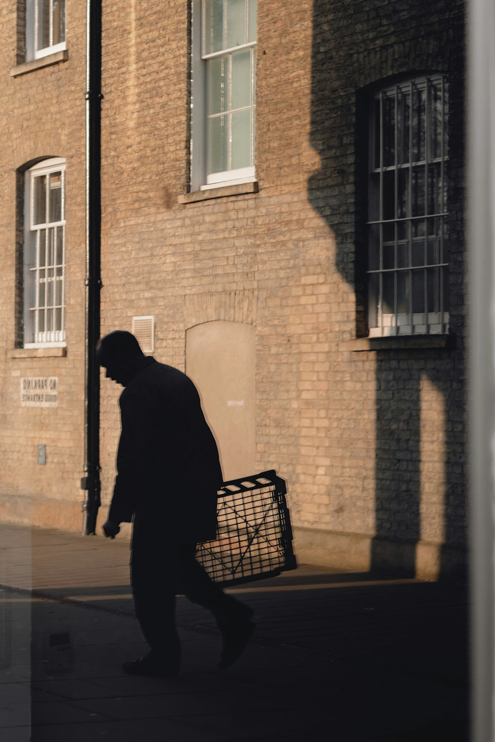 silhouette of man about to walk near building