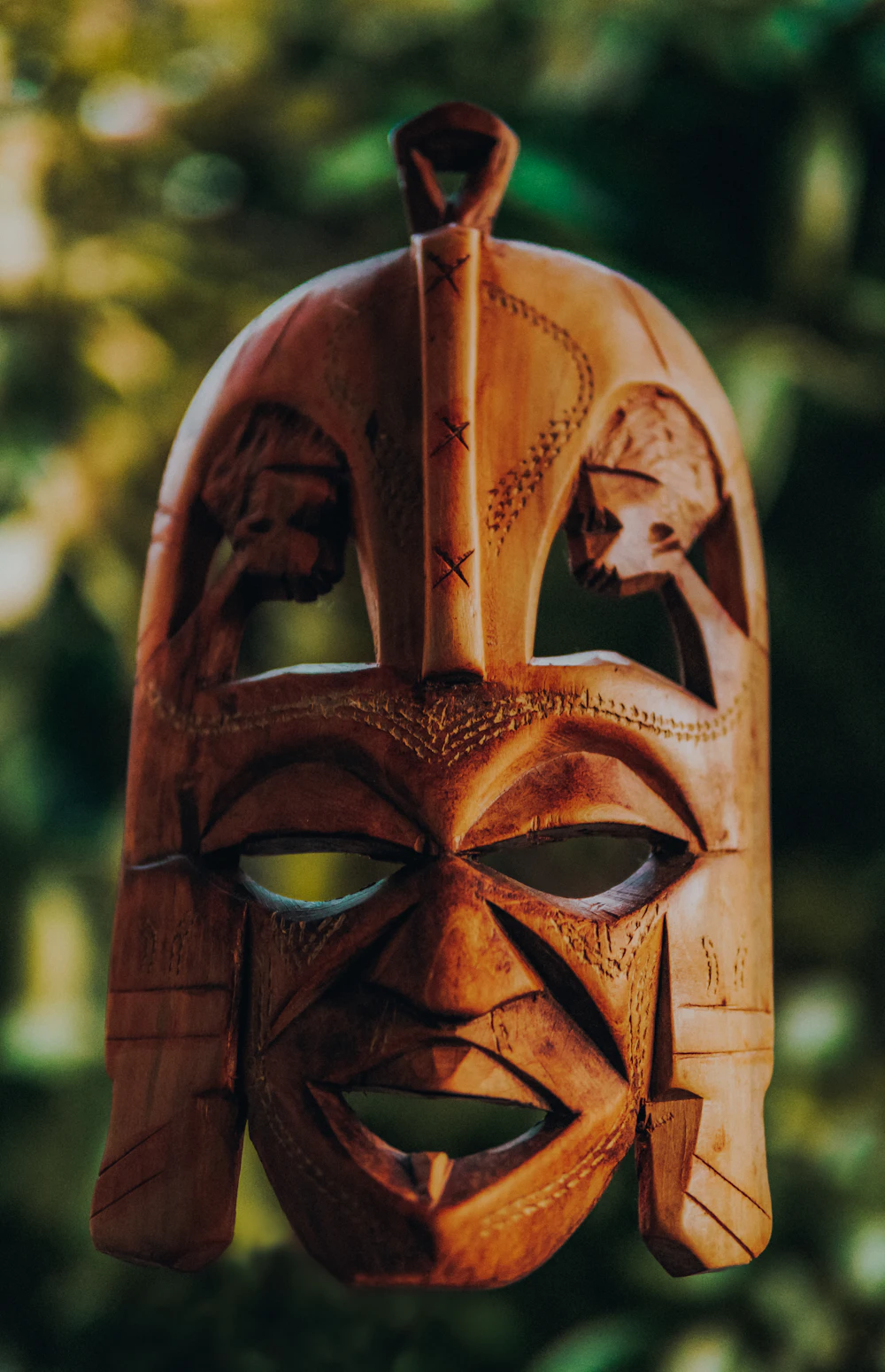 Close, tilt-shift study of a carved brown wooden mask