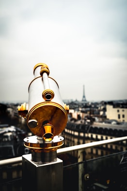 white and brass-colored coin-operated telescope near railings