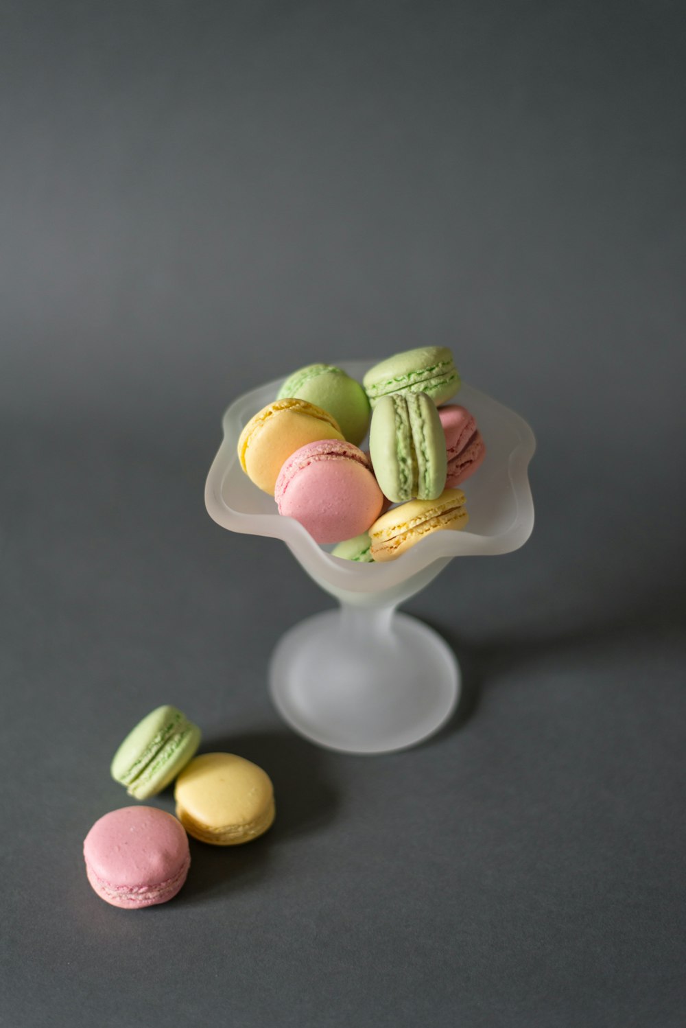 assorted-color macarons on gray footed bowl