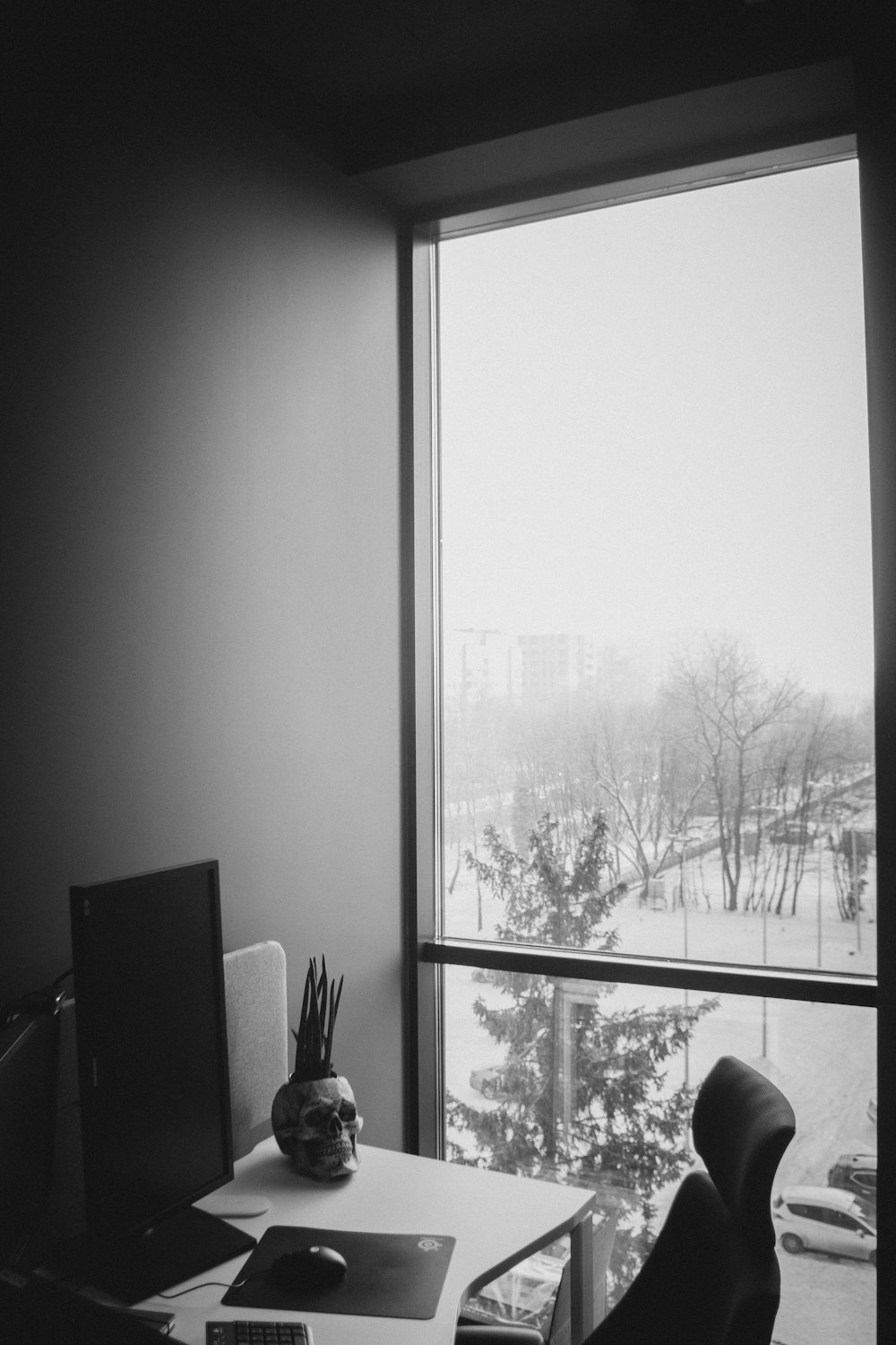 grayscale photography of rolling chair in front desk
