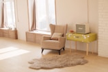 wing chair beside suitcase and window