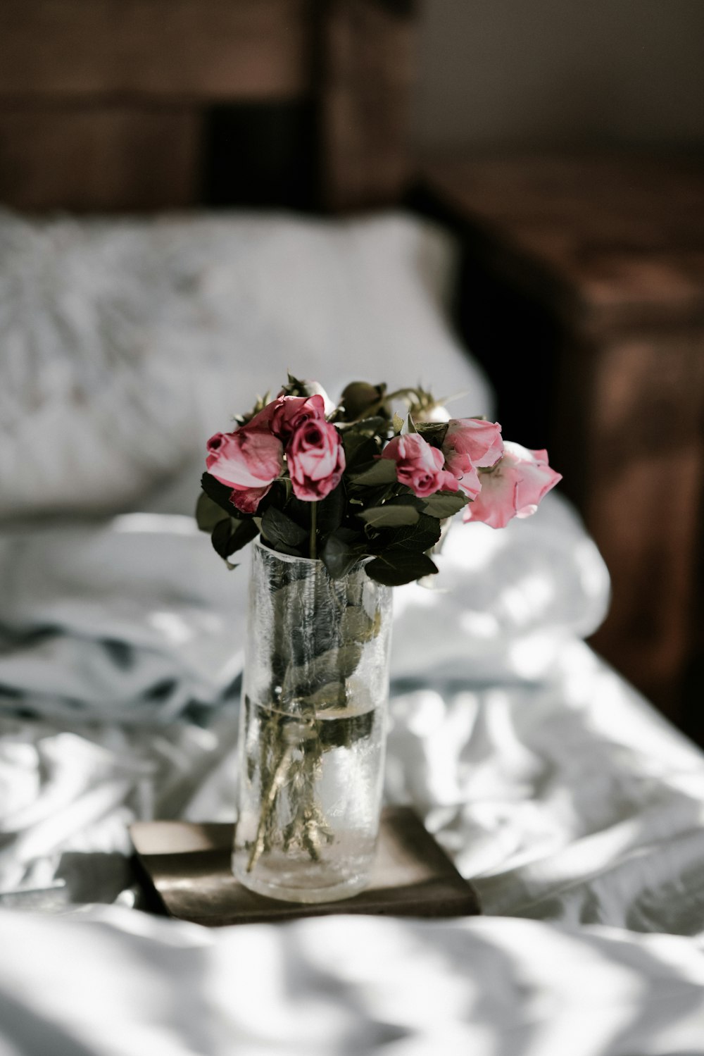 pink roses on clear glass vase