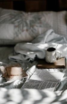 A peaceful morning scene with a journal, pen, and a cup of tea by a window with soft natural light.
